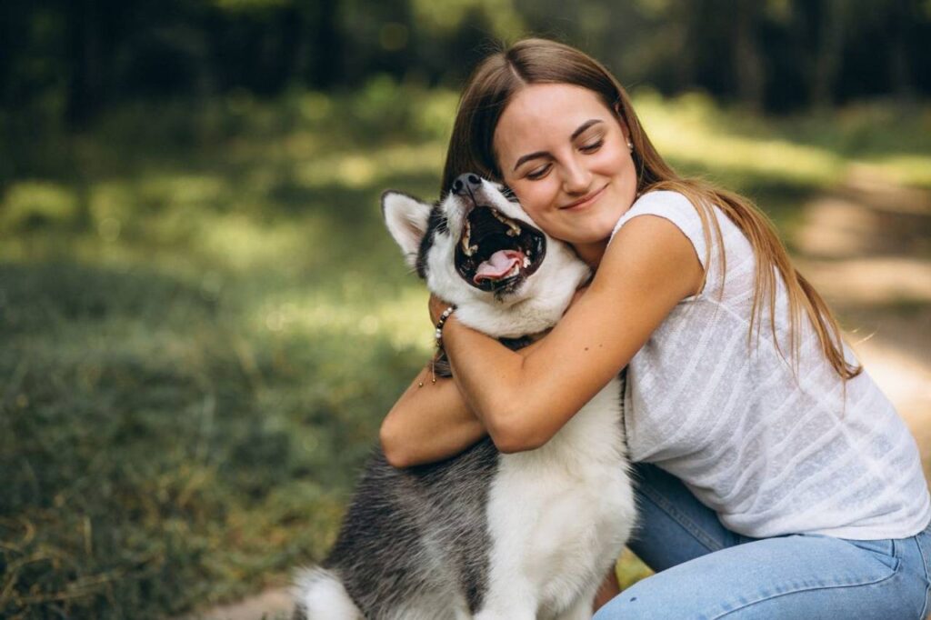 Mulher abraçando seu cachorro